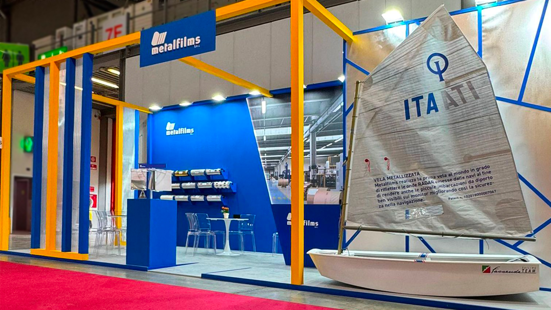 Stand Metalfilms allestito in fiera con materiali riflettenti e vela metallizzata esposta per dimostrazione tecnologica.