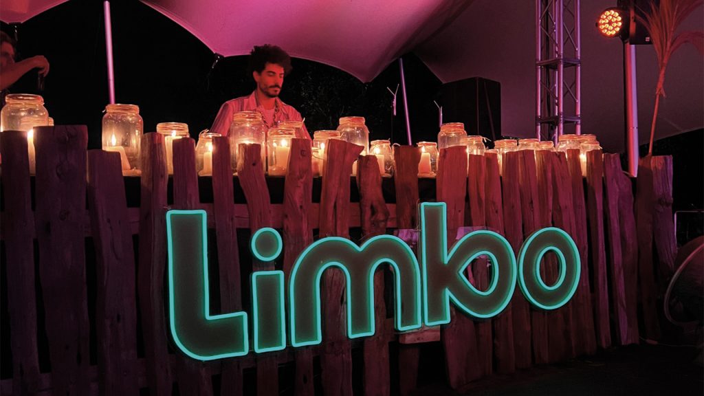 DJ al Limbo Festival di Lucca, evento serale con candele e scenografia in legno naturale.